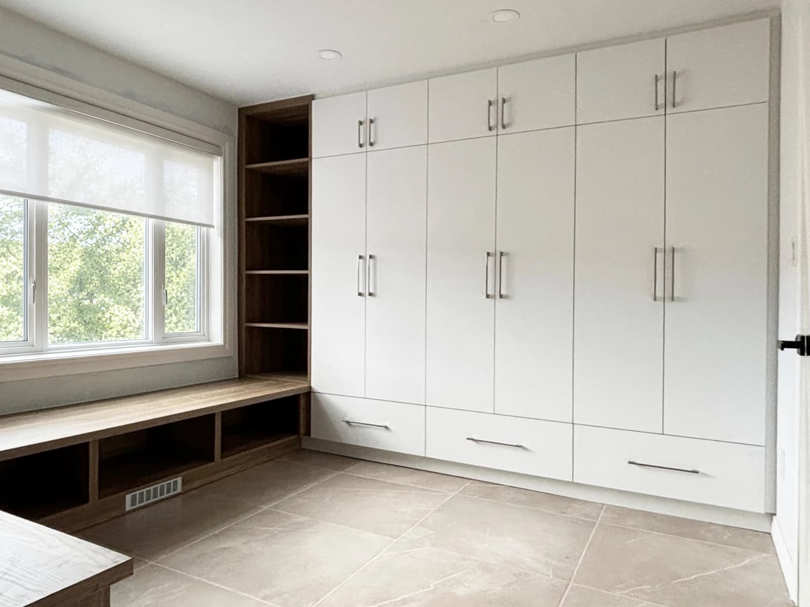 Built-in wardrobe connected to a long bench beneath a bedroom window