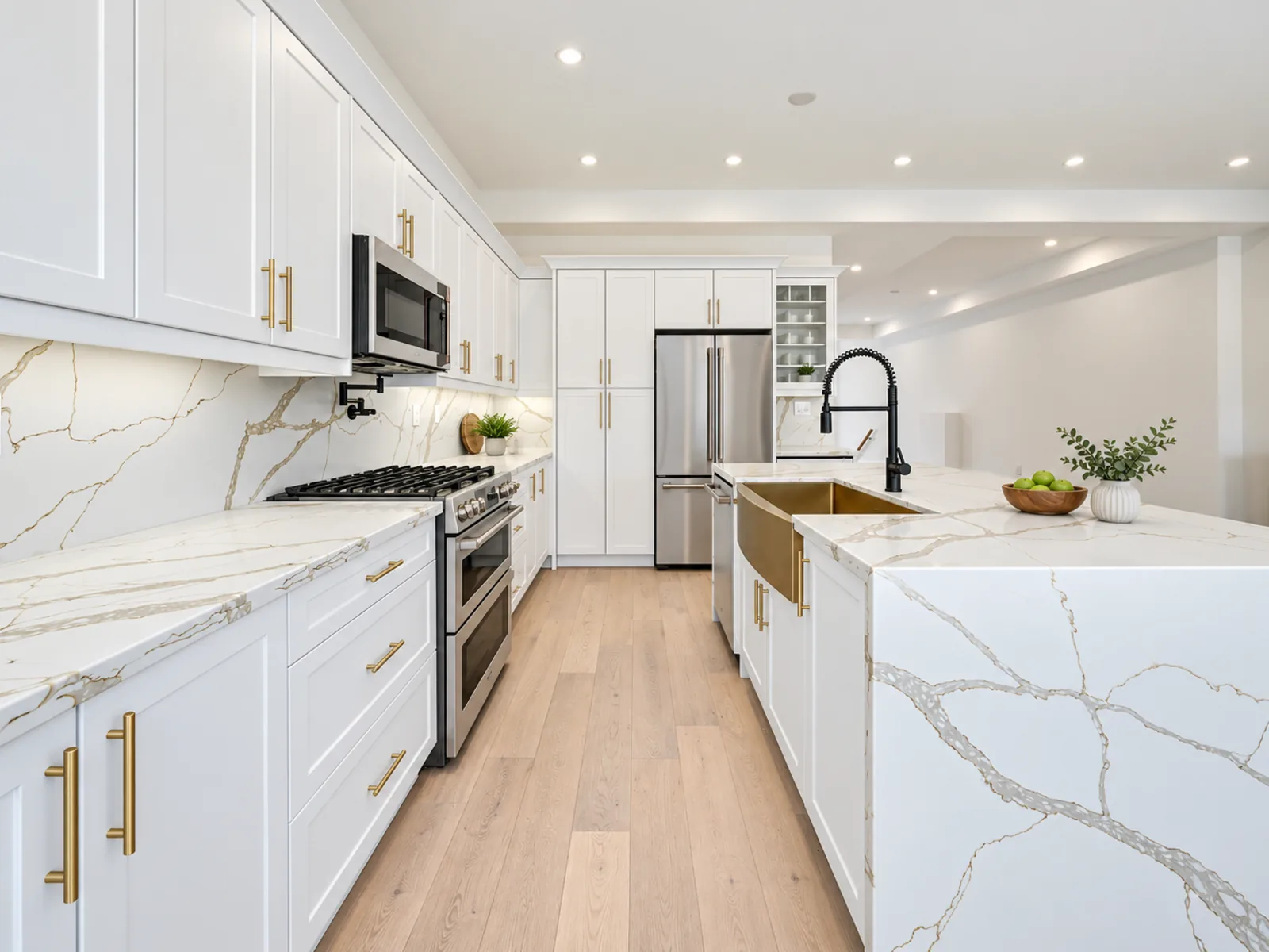 Completed transitional kitchen with white profiled cabinetry, brass-toned hardware, open display shelves and an extended island counter