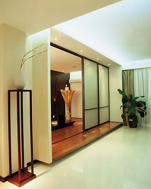 Dark-framed sliding room divider separating two furnished living spaces.