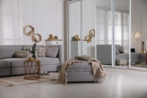 Comfortable Grey Sofa, Ottoman And Wardrobe With Mirror Doors In Comfortable grey sofa, ottoman and wardrobe with mirror doors in living room interior